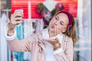 Woman blowing kiss and taking selfies