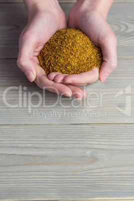 Woman showing handful of milled seed