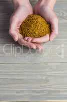 Woman showing handful of milled seed