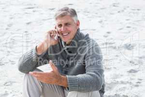 Smiling man sitting and on his phone