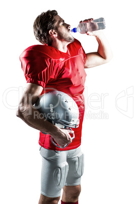 Thirsty American football player in red jersey drinking water