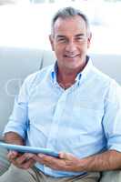 Smiling businessman holding digital tablet