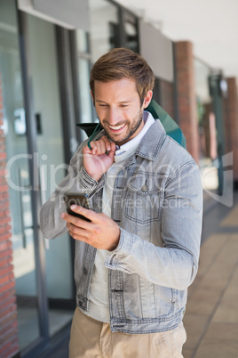 Young happy smiling man holding shopping bags and looking at his