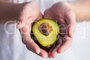 Woman showing fresh avocado