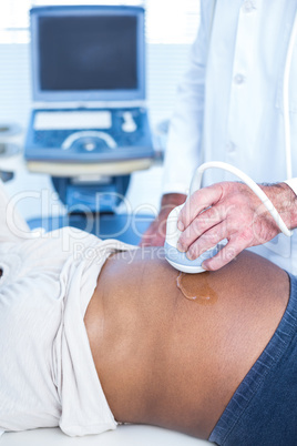 High angle view of male doctor performing ultrasound on woman