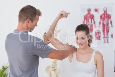 Doctor stretching a young woman arm