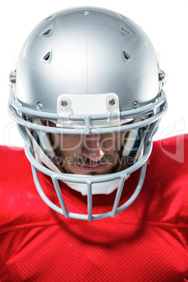 Confident American football player in red jersey looking down