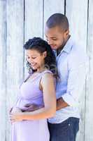 Happy pregnant couple touching belly