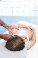 Masseur massaging shoulder of pregnant woman