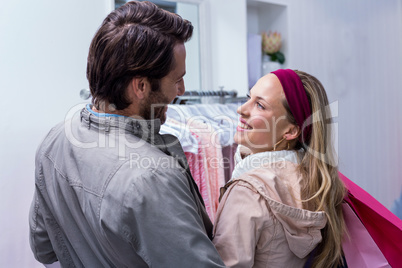 Smiling couple with shopping bags looking at each other