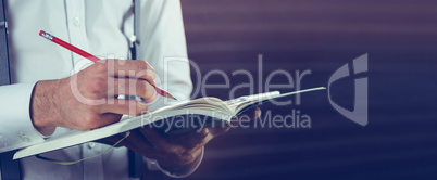 Midsection of businessman writing in his notebook