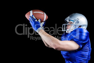 Side view of American football player looking at ball