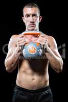 Portrait of shirtless athlete holding kettlebell