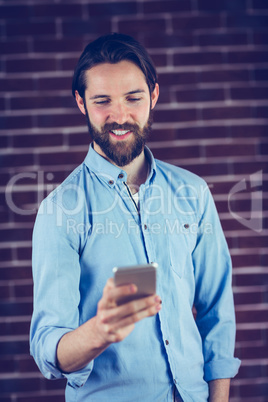 Smiling hipster using smartphone