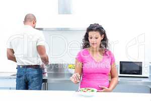 Husband helping pregnant wife in kitchen
