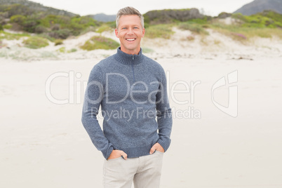 Smiling man standing with hands in his pockets Smiling man standing with hands in his pockets