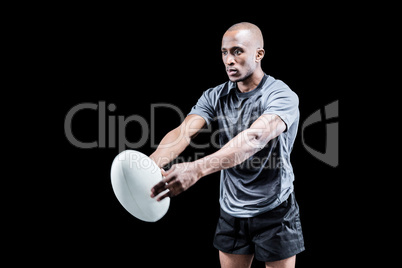 Rugby player with ball on black background