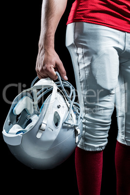 Cropped image of American football player holding helmet