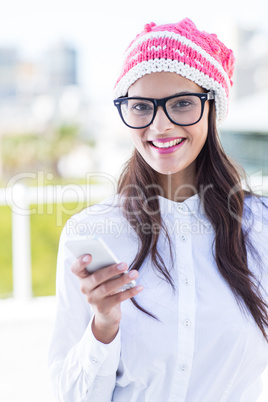 Happy pretty brunette using her smartphone