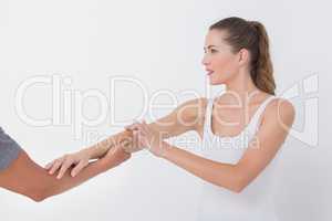 Doctor stretching a young woman arm