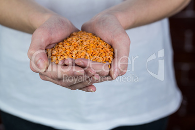 Woman showing handful of red lentils