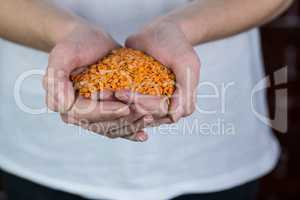 Woman showing handful of red lentils