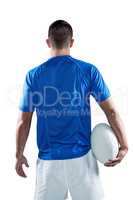 Rear view of rugby player holding ball aside