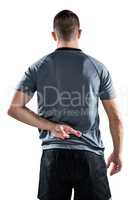 Rear view of rugby player with fingers crossed