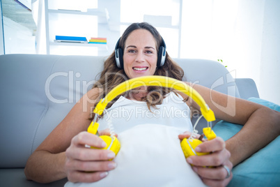 Pregnant woman listening to music at home