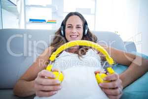 Pregnant woman listening to music at home