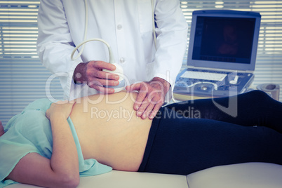 Male doctor performing ultrasound on woman