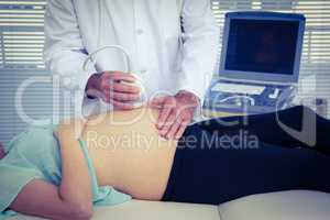 Male doctor performing ultrasound on woman