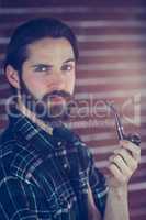 Portrait of confident hipster smoking pipe
