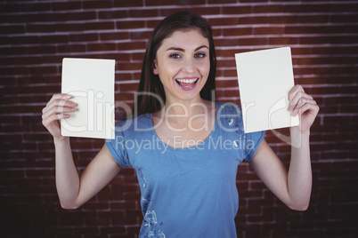 Pretty brunette holding two pages