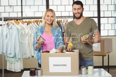 Portrait of happy colleagues smiling while holding products