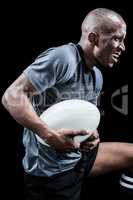 Aggressive sportsman with ball while playing rugby