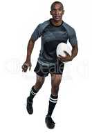 Confident athlete running with rugby ball