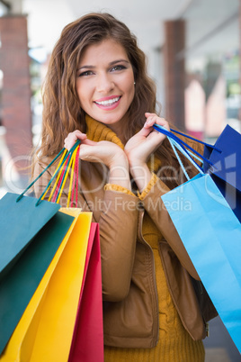 Portrait of smiling woman with shopping bags looking at camera