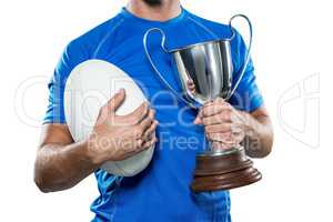 Rugby player holding trophy and ball