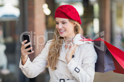 A smiling woman using her phone