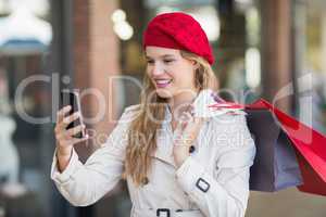 A smiling woman using her phone