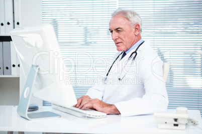 Thoughtful doctor working on computer