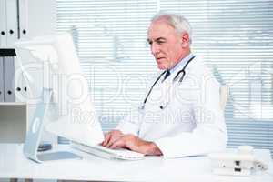 Thoughtful doctor working on computer