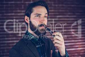 Handsome man with smoking pipe looking away