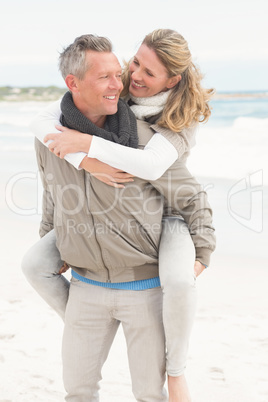 Smiling man giving woman a piggy back