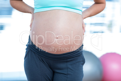 Mid section of pregnant woman in class