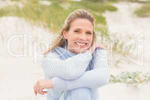 Smiling woman sitting on the sand