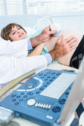 Midsection of doctor doing ultrasound test on woman