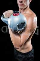 Midsection of shirtless sportsman working out with kettlebell