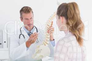 Doctor showing his patient a spine model